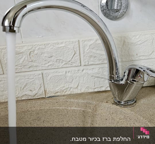 ברז מים זורם בכיור עם קרמיקה לבנה